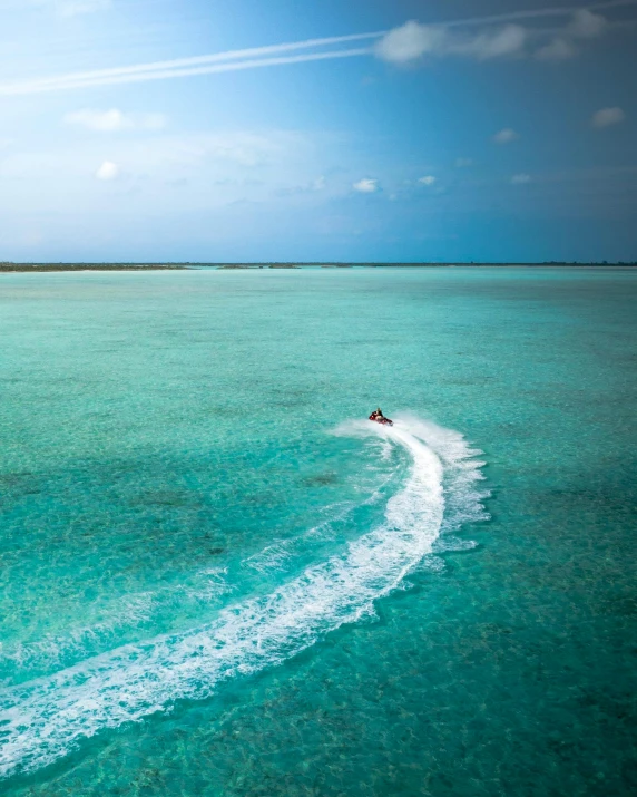 a person on a jet ski in the middle of the ocean, pexels contest winner, lush surroundings, thumbnail, maldives in background, today\'s featured photograph 4k