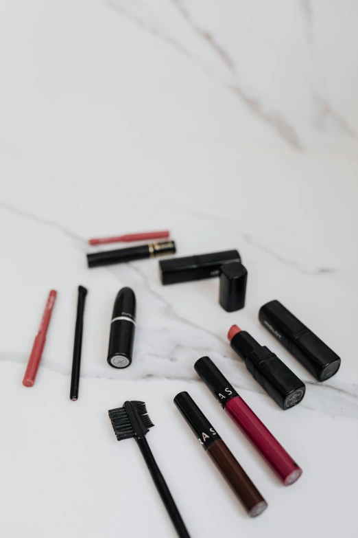 a number of different types of lipstick on a table, a picture, trending on pexels, visual art, black on white background, mascara, product, minimalistic