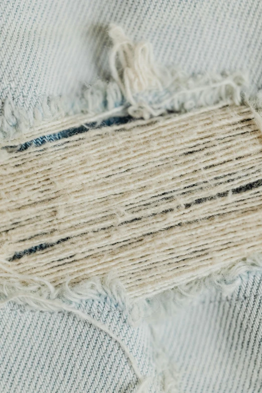a piece of fabric that has been torn off, unsplash, product label, detailed product image, hemp, detail shot