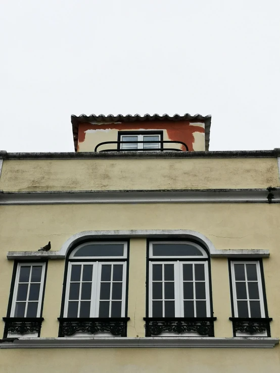 a building with a clock on top of it, the window, nazare (portugal), vibrant but dreary orange, low quality photo