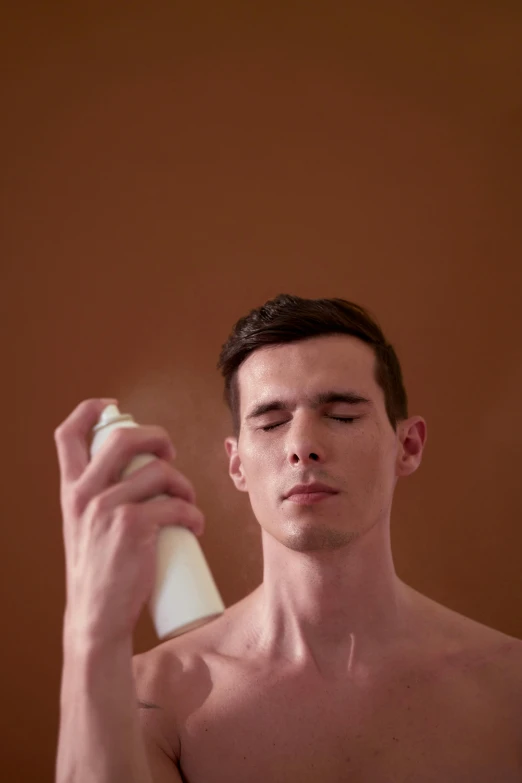 a shirtless man holding a spray bottle in front of his face, by artist, shutterstock, warm skin tone, incense, ((mist)), model photograph