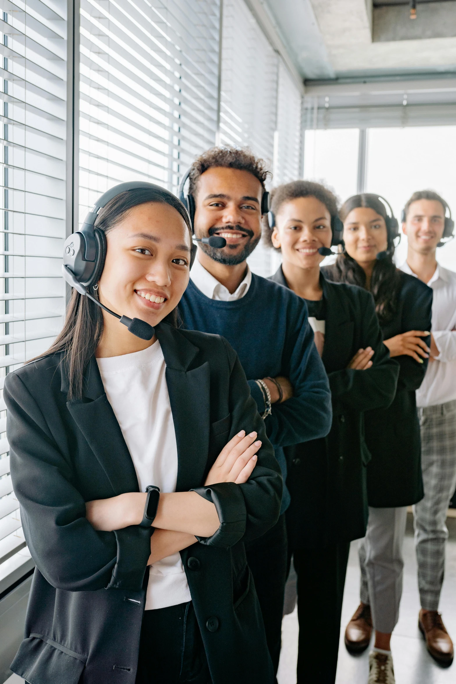 a group of people standing next to each other wearing headsets, varying ethnicities, office clothes, promo image, language