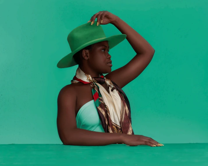 a woman wearing a green hat and scarf, an album cover, by Gavin Hamilton, trending on pexels, afrofuturism, an artistic pose, maria borges, ten-gallon hat, jade green