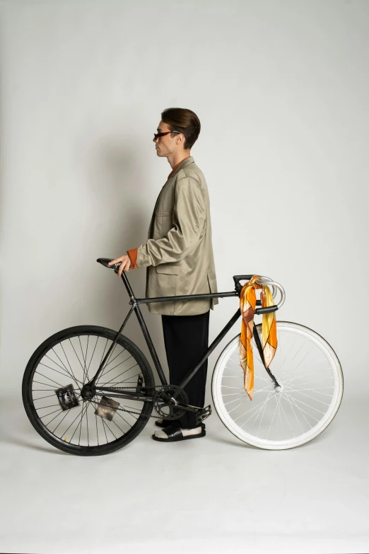 a man that is standing next to a bike, grey orange, profile image, designer product, over-shoulder shot