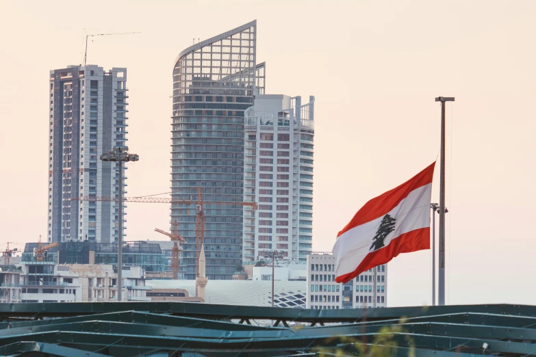 a large flag flying in front of a tall building, by Daniel Lieske, pexels contest winner, hurufiyya, portait of haifa wehbe, skyscrapers in the background, early in the morning, megastructure in the background