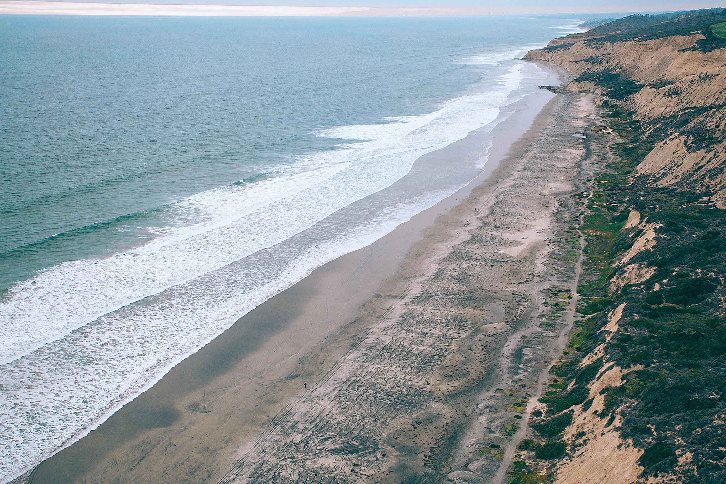 an aerial view of a beach next to the ocean, by Thomas Furlong, unsplash contest winner, hollister ranch, coastal cliffs, profile image, historical photo