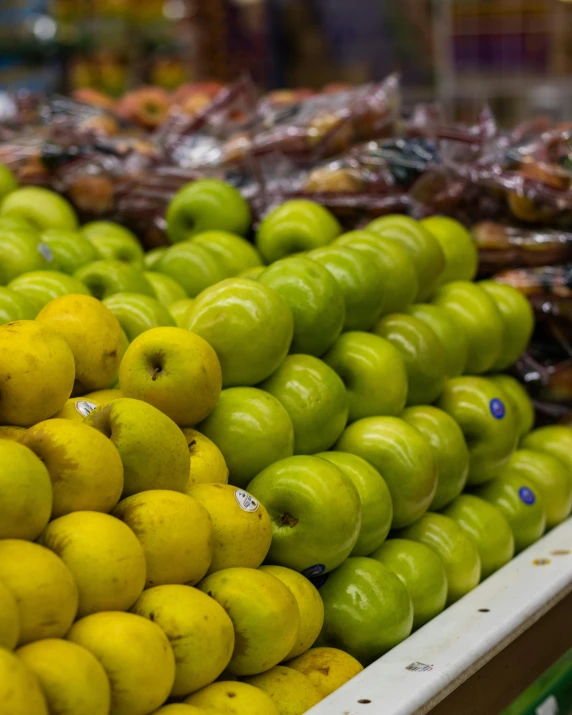 a display in a grocery store filled with lots of green apples, by Meredith Dillman, pexels, made of glazed, ivan bolivian, yellow and olive color scheme, petite pear slim figure