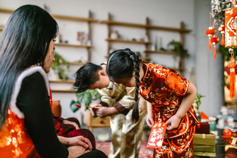 a couple of women standing next to each other, pexels contest winner, cloisonnism, families playing, wearing red attire, gemma chen, kids playing