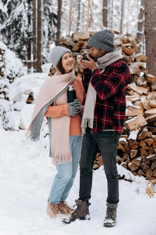 a man and woman standing next to each other in the snow, pexels contest winner, drinking champagne, lumberjack, warm cosy colors, grey