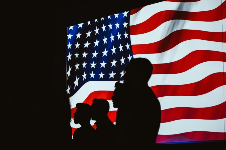 a man and a woman standing in front of an american flag, pexels contest winner, symbolism, silhouettes of people, projection mapping, profile image, inauguration
