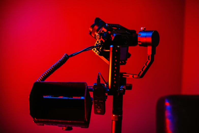 a close up of a camera on a tripod, by Adam Marczyński, unsplash, video art, red and blue back light, red weapon 8 k s 3 5, on a red background, cinematic outfit photo