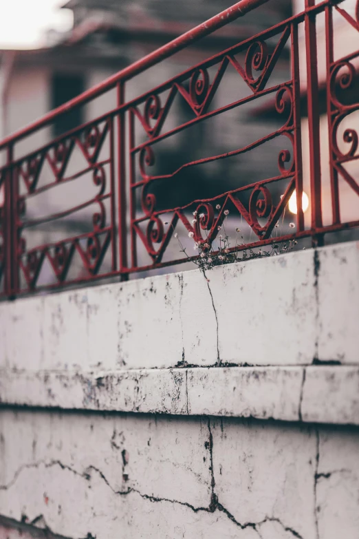 a fire hydrant sitting on top of a cement wall, inspired by Elsa Bleda, pexels contest winner, iron railing, white and red color scheme, balcony, low-light