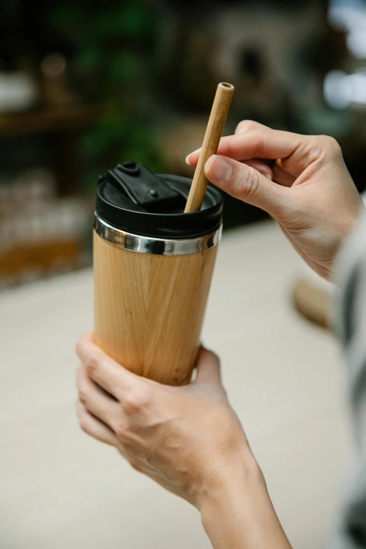 a person holding a cup with a straw in it, natural wood top, recycled, thumbnail, port