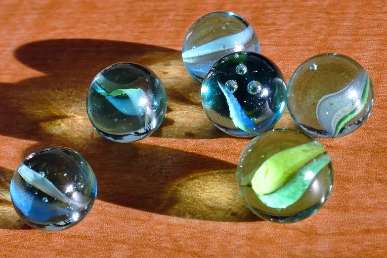 a group of marbles sitting on top of a wooden table