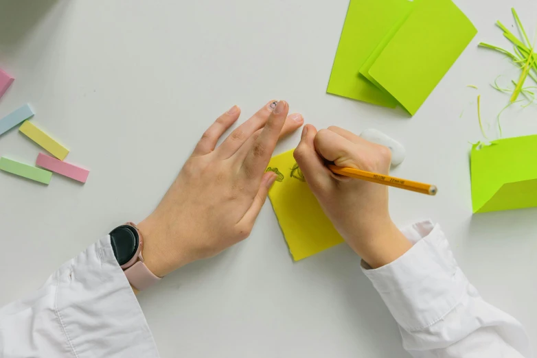 a person writing on a piece of paper with a pencil, lime green, origami studio 3 design, thumbnail, neuroscience