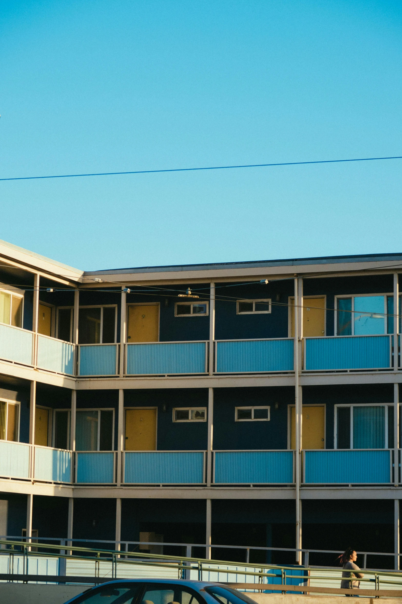 a car that is parked in front of a building, inspired by Wes Anderson, unsplash, modernism, blue and gray colors, hotel room, in an american suburb, exterior view