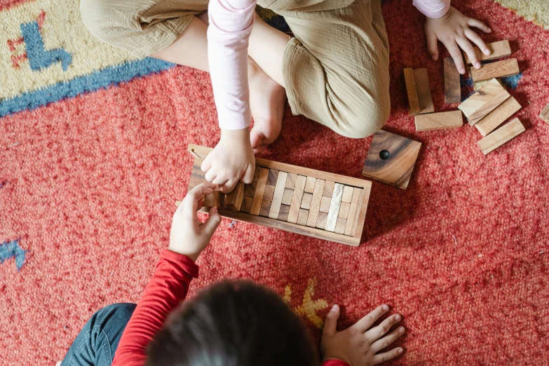 two children playing with wooden blocks on the floor, a jigsaw puzzle, inspired by Hubert Robert, unsplash, japanese collection product, teaser, brown, striped