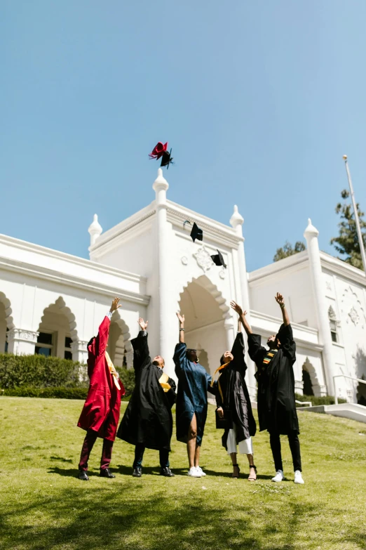 a group of people standing on top of a lush green field, academic art, moorish architecture, waving robe movement, post graduate, hollywood standard