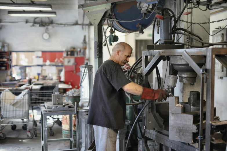 a man working on a machine in a factory, by Joe Stefanelli, cast iron material, full daylight, alfio presotto, customers