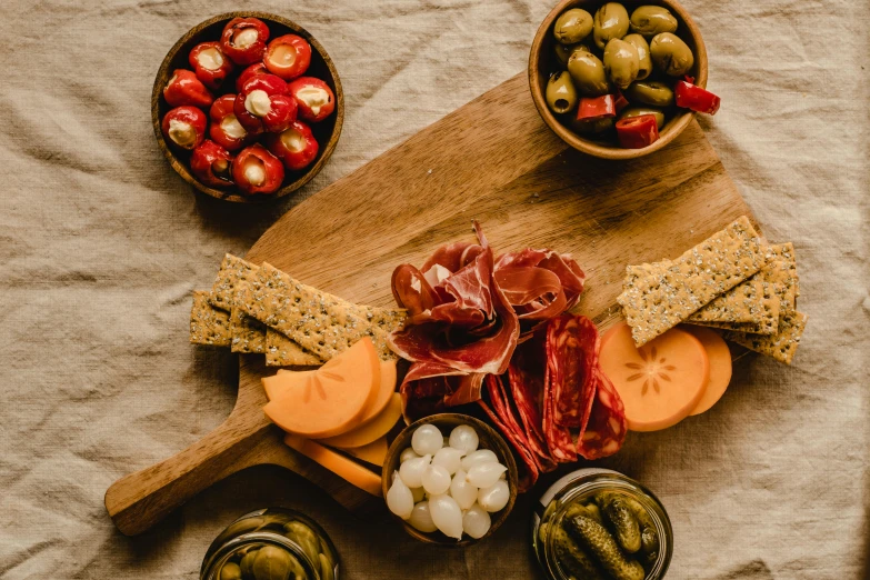 a wooden cutting board topped with cheese and olives, by Carey Morris, pexels contest winner, pickles, crimson themed, 1 6 x 1 6, thumbnail