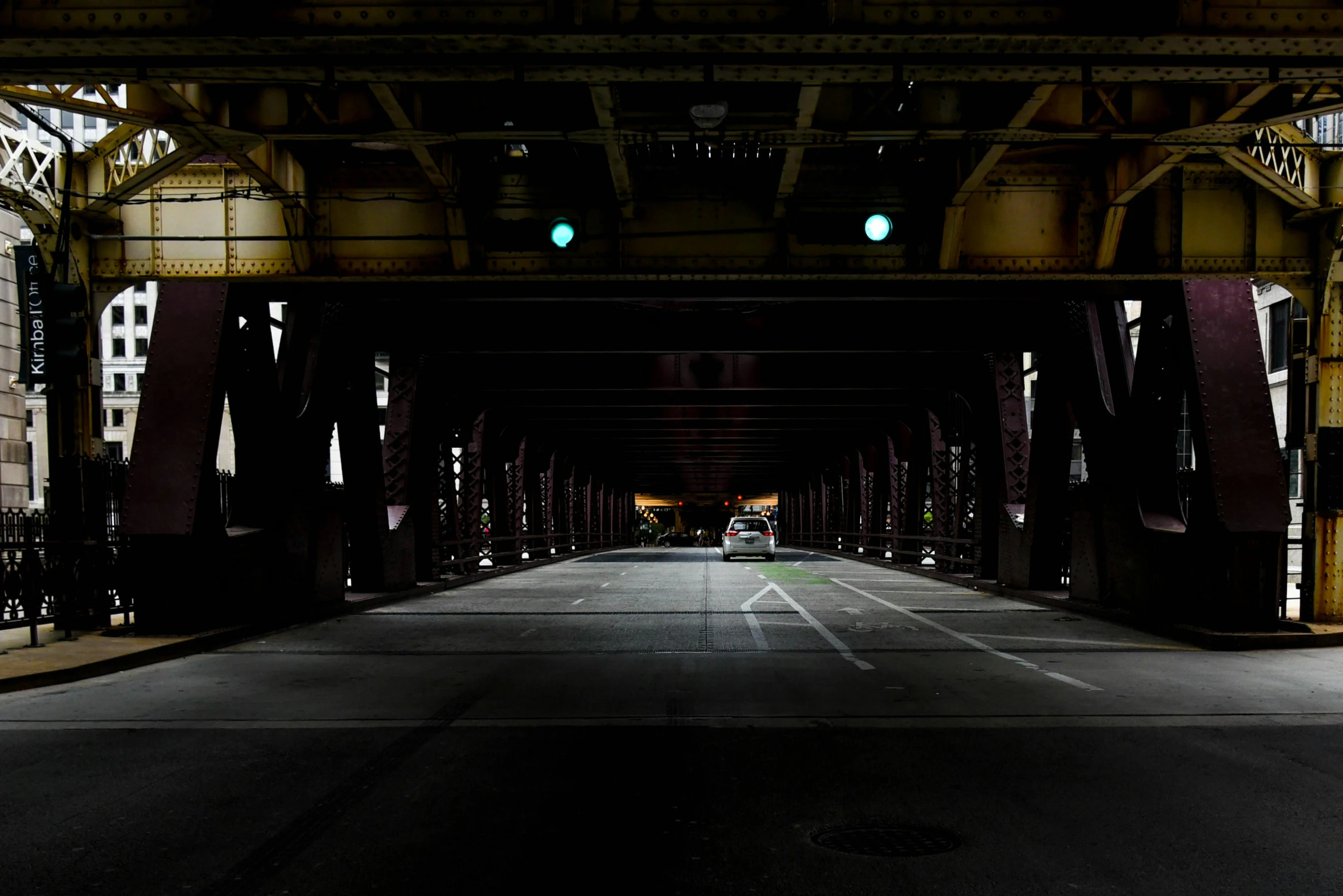 a green traffic light sitting on the side of a road, a portrait, by Andrew Domachowski, unsplash, graffiti, under bridge, chicago, symmetric lights, inside a grand