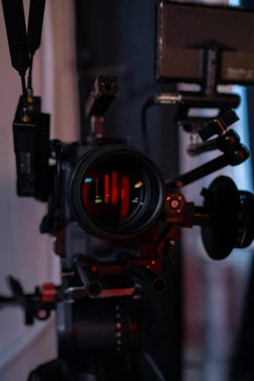 a close up of a camera on a tripod, by Ryan Pancoast, holography, red and cinematic lighting, with anamorphic lenses, 6 0 mm lens in full armor, studio camera