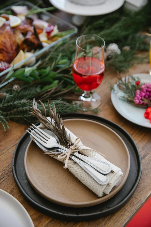 a wooden table topped with plates and silverware, holiday season, botanicals, drinking, hay