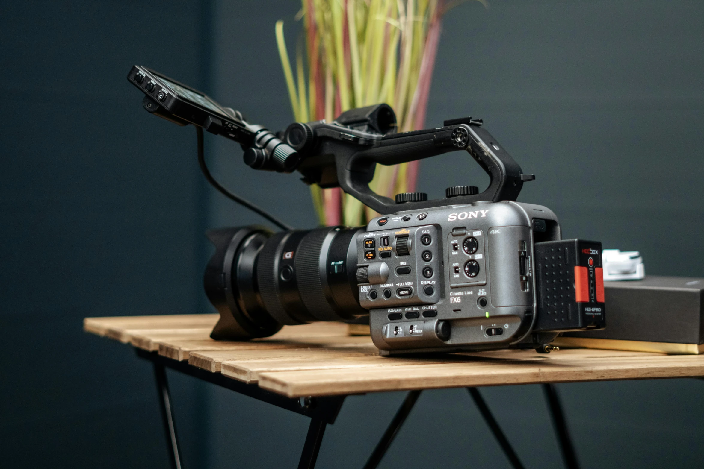 a camera sitting on top of a wooden table, sony fx 6, grey metal body, delightful surroundings, ue5