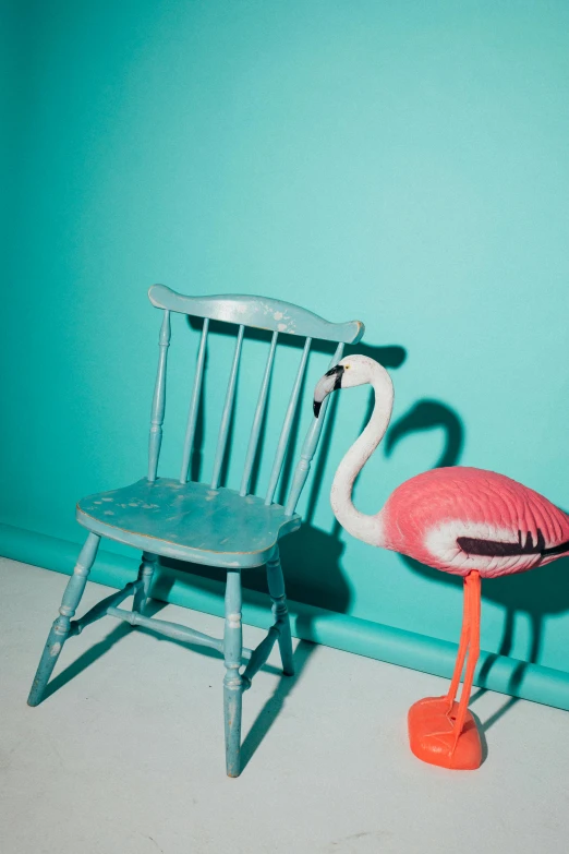 a pink flamingo standing next to a blue chair, by Elsa Bleda, caleb worcester, andrew thomas huang, teal, real life size