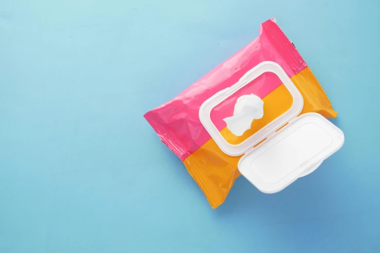 a pack of baby wipes sitting on top of a blue surface, plasticien, pink and orange, square, no - text no - logo, editor’s pickup