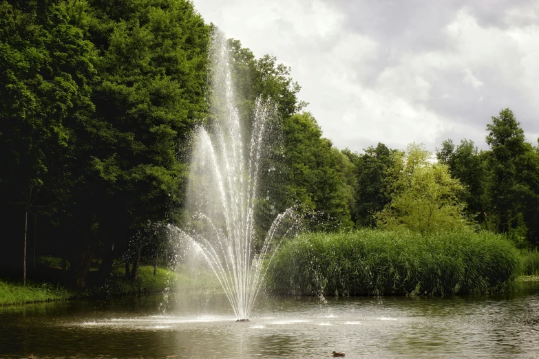 a water fountain in the middle of a lake, commercial photograph, 3 0 0 mm, celestial gardens, fan favorite