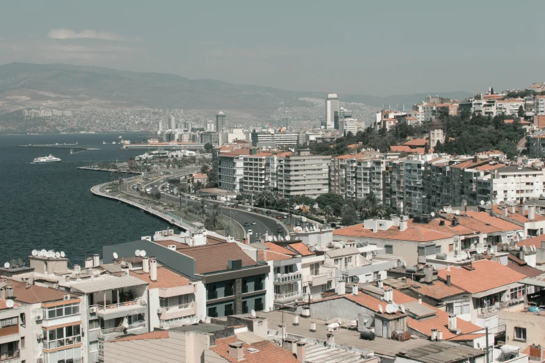 a view of a city next to a body of water, a colorized photo, pexels contest winner, les nabis, demna gvasalia, high - angle view, can basdogan, grey