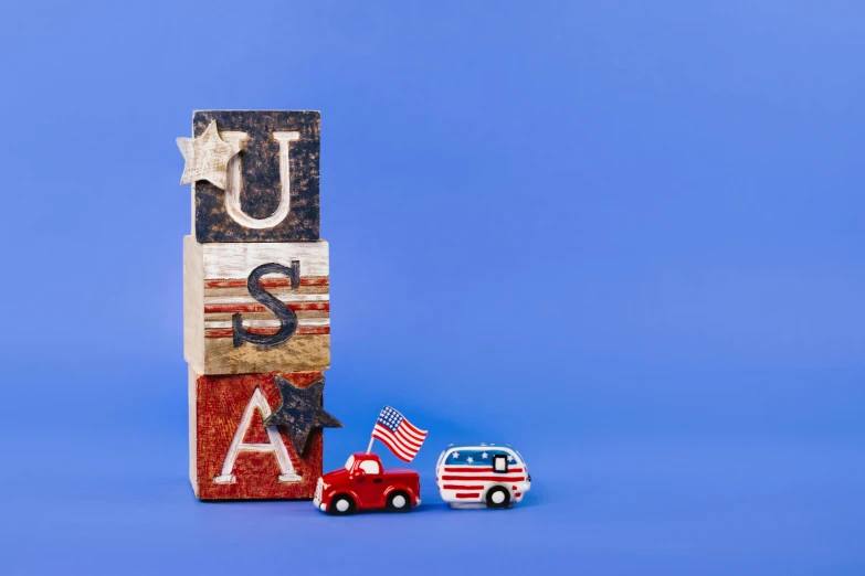 a toy truck sitting next to a block with the word usa written on it, an album cover, by Julia Pishtar, unsplash, american scene painting, flags, stacked image, profile picture, full product shot