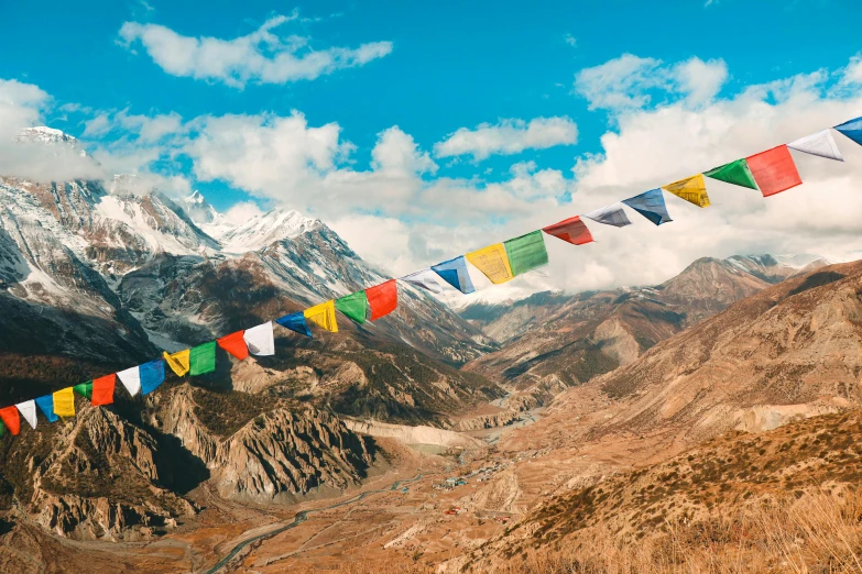 a group of colorful flags hanging from the side of a mountain, trending on unsplash, hurufiyya, thangka, avatar image