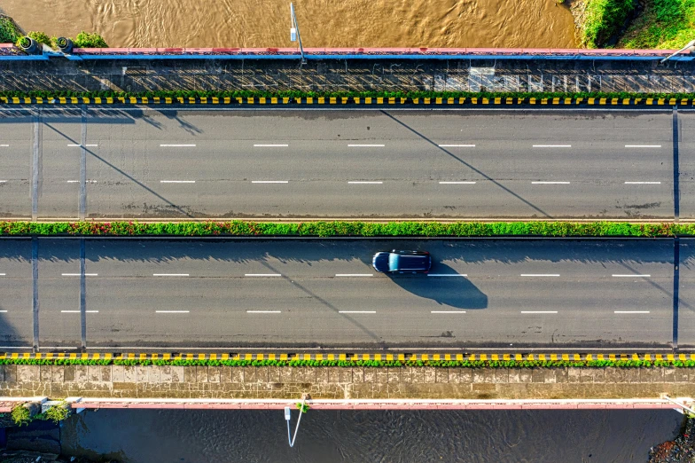an aerial view of a highway next to a body of water, an album cover, pexels contest winner, floods, vietnam, vehicle, thumbnail