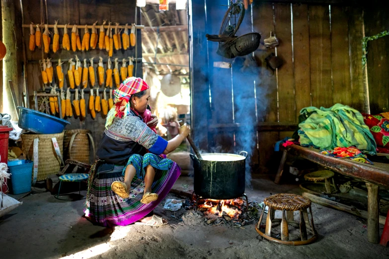 a woman that is sitting in front of a stove, by Daniel Lieske, pexels contest winner, bamboo huts, pichacu cooks a squid, avatar image, bao phan