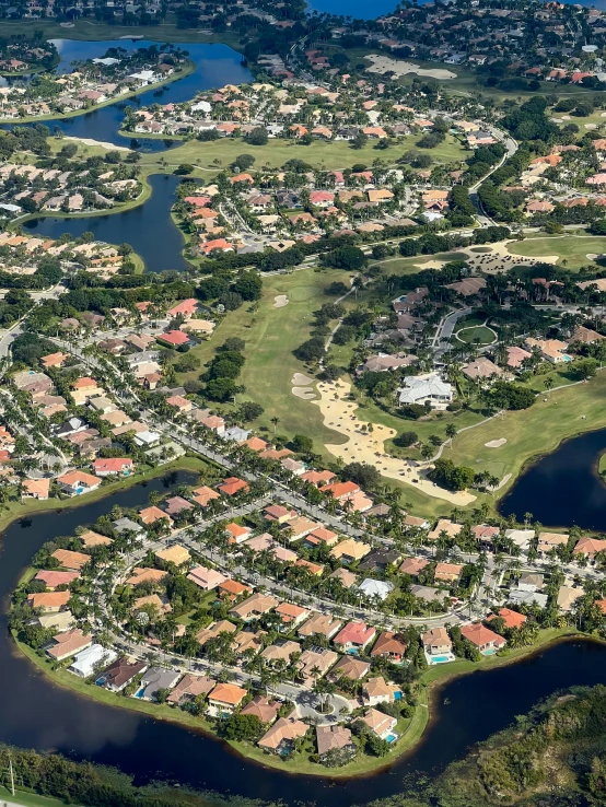 a bird's eye view of a golf course, happening, waterfront houses, tiled roofs, 8 k image