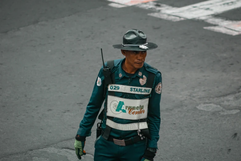 a police officer is walking down the street, pexels contest winner, sumatraism, silver and emerald breastplate, philippines, pilot outfit, sentinel