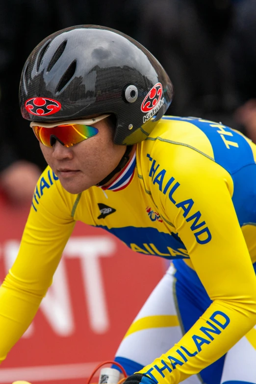 a man riding a bike wearing a yellow and blue jersey, thawan duchanee, helmond, sport glasses, thumbnail