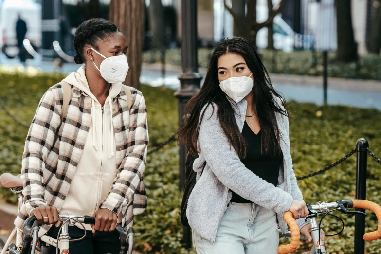 a couple of people standing next to each other on bikes, trending on pexels, happening, medical mask, two girls, jen yoon, polluted