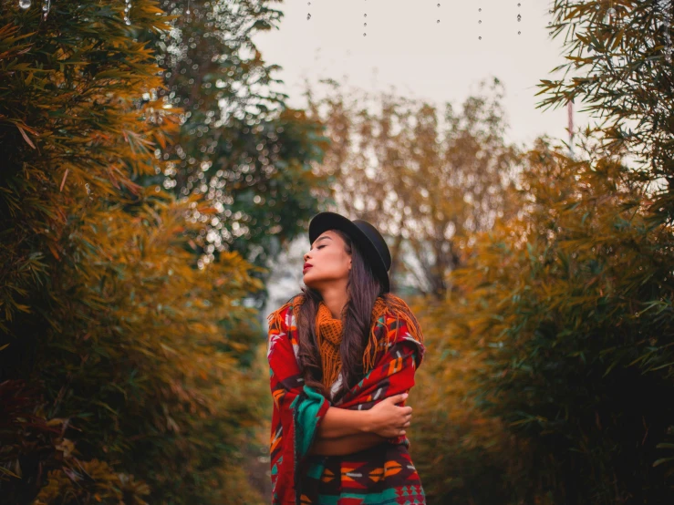 a woman standing in the middle of a forest, pexels contest winner, colorful clothes, beautiful mexican woman, fall season, in garden