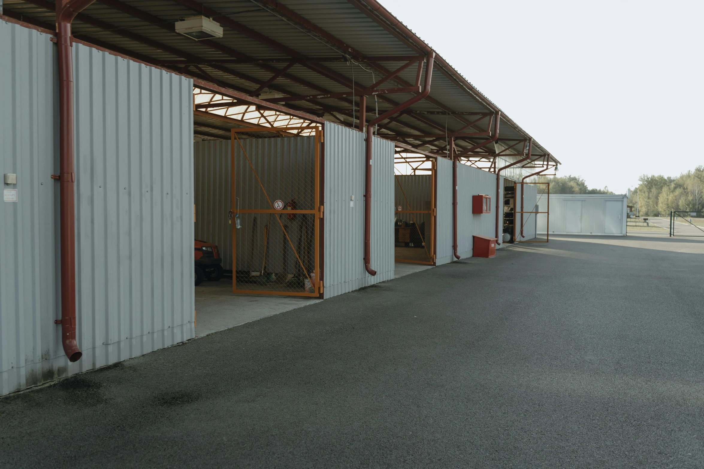 a red fire hydrant sitting in the middle of a parking lot, by Cricorps Grégoire, les nabis, inside a shed, of augean stables, profile image, minimal structure