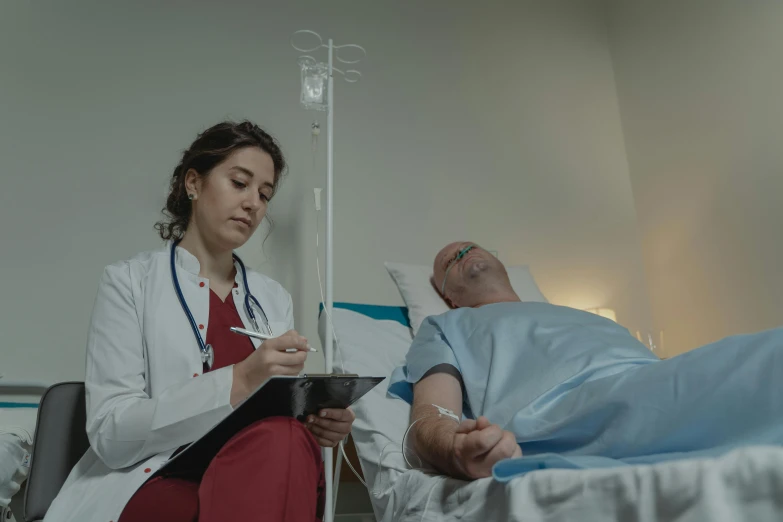 a woman sitting next to a man in a hospital bed, a colorized photo, pexels contest winner, paul barson, med bay, 4 k cinematic photo, background image