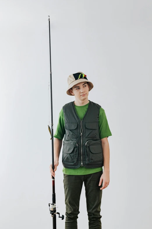a boy in a green shirt is holding a fishing pole, model is wearing techtical vest, curated collection, green: 0.5, multiple stories