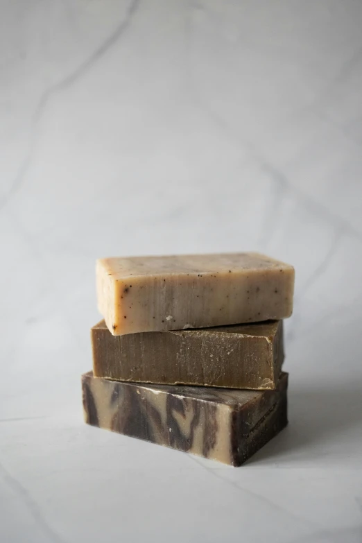 three soap bars stacked on top of each other, by Jessie Algie, charred, dirty olive skin, side shot, thumbnail