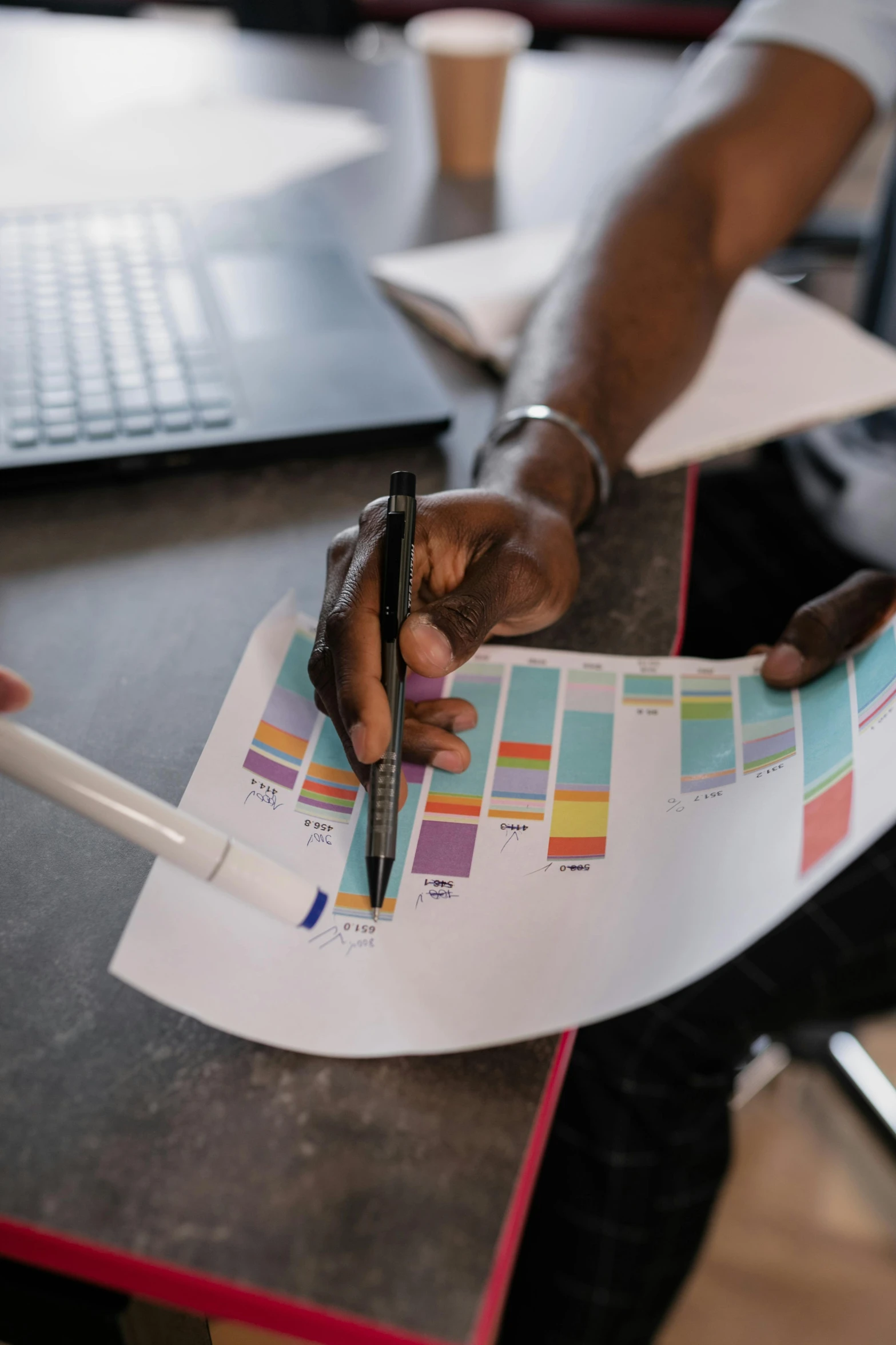 a person sitting at a table with a pen and paper, pexels contest winner, analytical art, bar charts, diverse colors, medium shot of two characters, branding