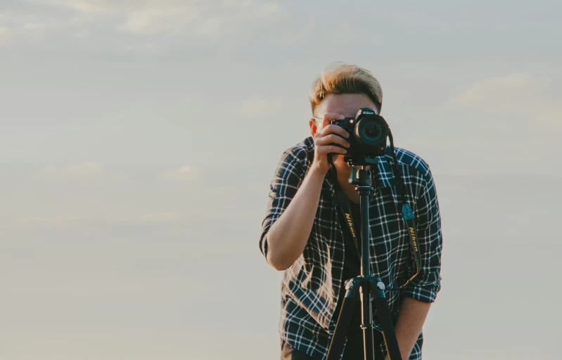 a man taking a picture with a camera, pexels contest winner, towering over the camera, carson ellis, photo high definition, plain background