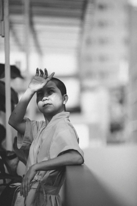 a black and white photo of a young boy, by Yosa Buson, pexels contest winner, saluting, thawan duchanee, mime, sunburn