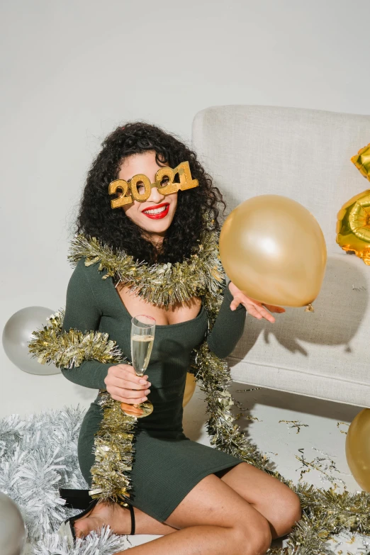 a woman sitting on a couch holding a glass of champagne, a polaroid photo, trending on pexels, happening, party balloons, gold suit, long curly green hair, (1 as december