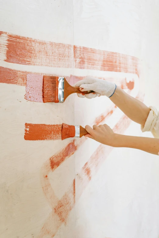 a woman is painting a wall with red paint, striations, thumbnail, listing image